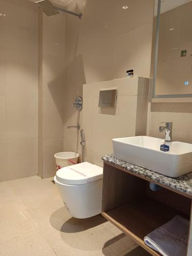 a bathroom with a white toilet and a sink at Rudram Inn in Varanasi