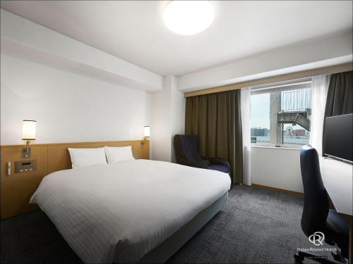 a hotel room with a bed and a window at Daiwa Roynet Hotel Hakata-Gion in Fukuoka