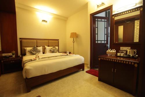a bedroom with a large bed and a mirror at Grand Cascade Chennai in Chennai