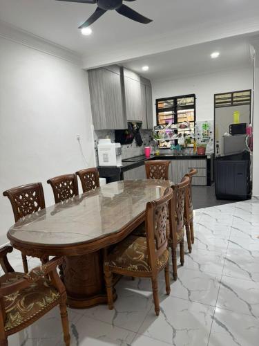 a kitchen with a wooden table and chairs at Student Homestay in Kampong Ru Sepuloh