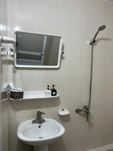 a bathroom with a sink and a mirror on the wall at Sunshine Loop Hostel in Làng Lap