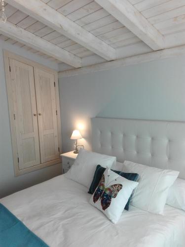 a white bed with two pillows on top of it at Casas Rurales Prunus Avium in Cambrón