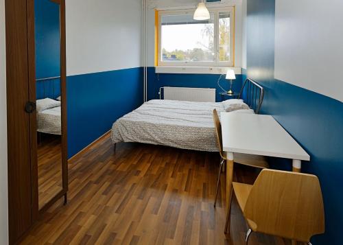 a room with a bed and a table and a window at CheapSleep Hostel Helsinki in Helsinki