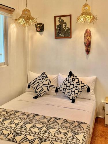 a bed with black and white pillows in a room at Brisa Room T in El Nido Airport