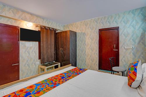 a bedroom with a bed with a colorful blanket on it at FabHotel Shree Ji in Lucknow