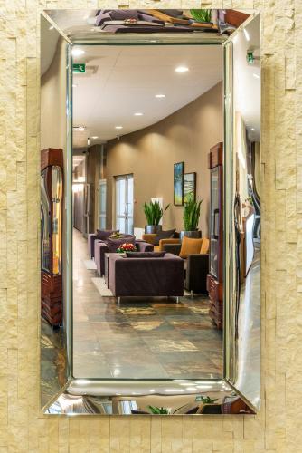 a mirror in a room with couches and chairs at Hotel Victor Pruszków DeSilva in Pruszków