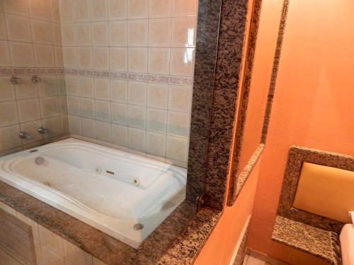 uma banheira na casa de banho com um chuveiro em Love Story (Adult Only) em Salvador
