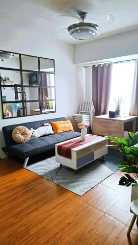 a living room with a couch and a coffee table at Family Haven Tagaytay - 1 BR - up to 6 Pax - Taal View - Full Kitchen - FAST Wi-Fi - in Tagaytay