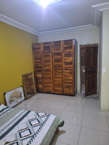 ein Zimmer mit zwei Betten und Holzschränken in der Unterkunft Affiba Colocation in Abidjan