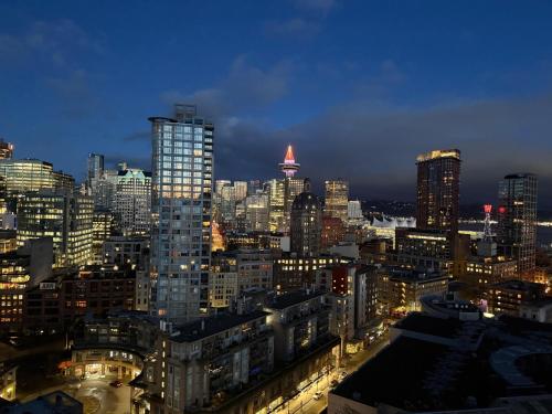 a view of a large city at night at Two Bedroom Apartment with stunning 180 water, mountain and city view Pool Hot Tub and Gym Heart of Downtown Skytrain 3mins walk Right by BC Place Rogers arena in Vancouver