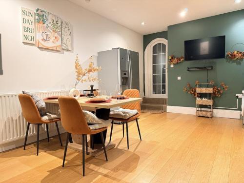 a living room with a table and chairs and a tv at Autumn’s Retreat in Newcastle upon Tyne