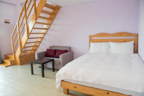 a bedroom with a bed and a chair and a staircase at Country Lane in Checheng
