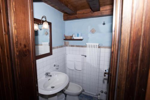 La salle de bains est pourvue de toilettes blanches et d'un lavabo. dans l'établissement Club Esse Pila 2000, à Pila