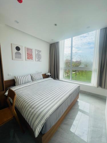 a bedroom with a large bed with a large window at Sò homestay in Thôn Văn Dương