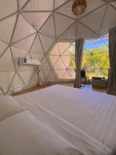 a room with a large white bed in a yurt at khaolakcamping in Ban Lam Ru (1)