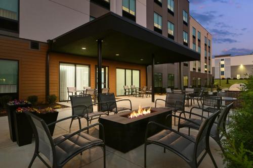 a patio with chairs and a fire pit in front of a building at Hyatt Studios Huntsville in Huntsville