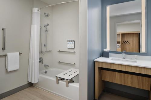 a bathroom with a sink and a tub and a toilet at Hyatt Studios Huntsville in Huntsville