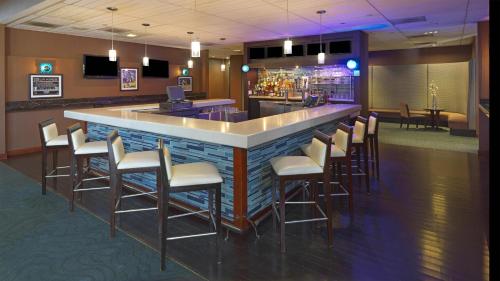 a bar with a bunch of chairs around it at Ontario Airport Hotel & Conference Center in Ontario