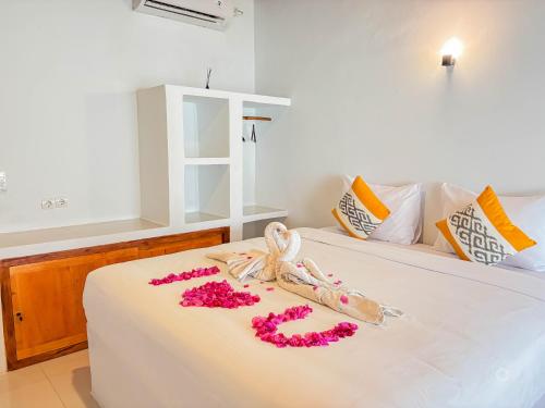 a bedroom with a bed with flowers on it at Trytan Gerupuk Homestay in Bumbang