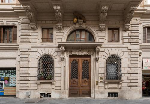 a building with a wooden door and three windows at Affreschi Su Roma Luxury B&B in Rome