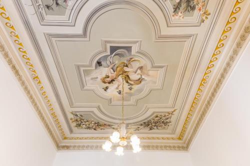 an ornate ceiling with a chandelier in a room at Affreschi Su Roma Luxury B&B in Rome