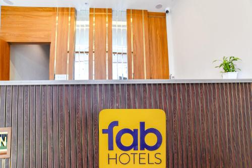 a fida hotel sign on a wooden wall at FabHotel Olive Inn in Indore