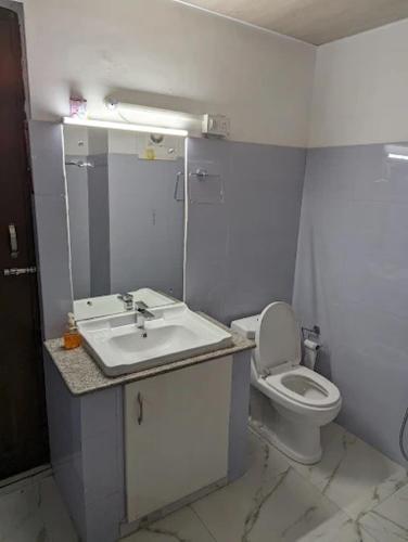 a white bathroom with a sink and a toilet at Hotel The White Castle Kargil in Kargil