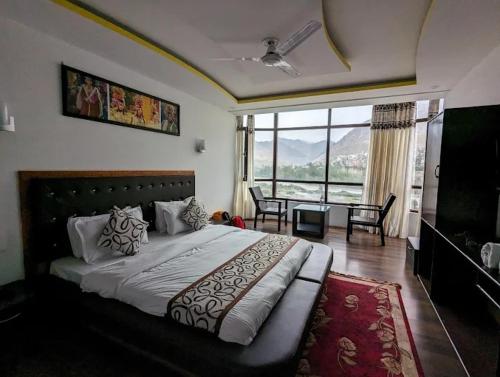 a bedroom with a large bed and a dining room at Hotel The White Castle Kargil in Kargil