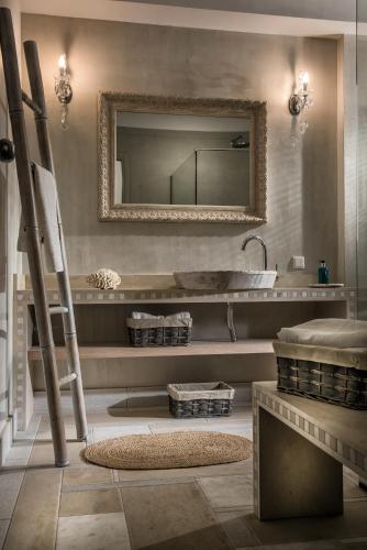 a bathroom with a mirror and a sink at Sunvillage Malia Boutique Hotel and Suites in Malia