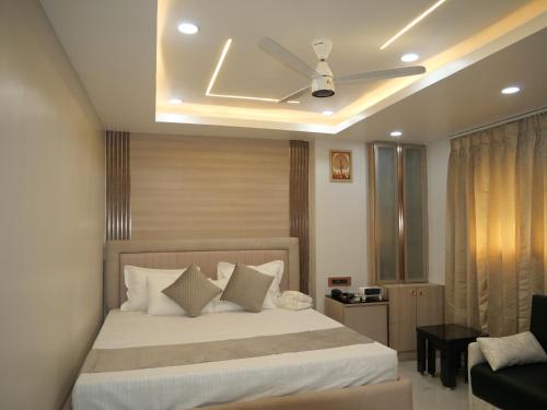 a bedroom with a bed and a ceiling fan at Happy Residency in Patna