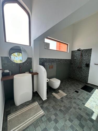 a bathroom with a white toilet and a sink at Arabian Coral in Ḩaḑbaram