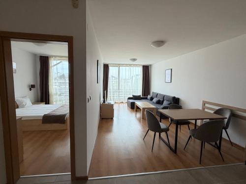 a room with a bed and a table and chairs at Aspen Golf and Ski Resort in Bansko
