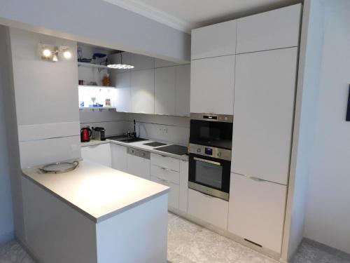 une cuisine blanche avec des armoires et des appareils blancs dans l'établissement Appartement Regency, à Menton