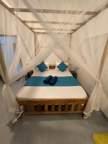 a bed in a tent with blue pillows on it at Dew home stay in Dickwella