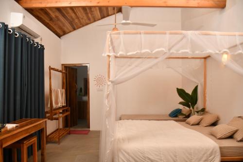 a bedroom with a white canopy bed in a room at Solara Arugam Bay in Arugam Bay