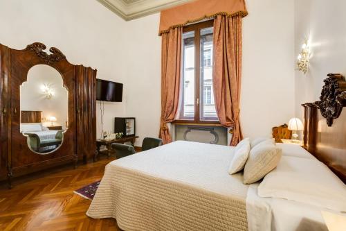 a bedroom with a large bed and a mirror at Affreschi Su Roma Luxury B&B in Rome