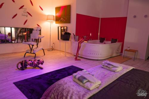 a room with a bed and a tub in it at LoveRoom Les Folies Douces & Spa in Nancy
