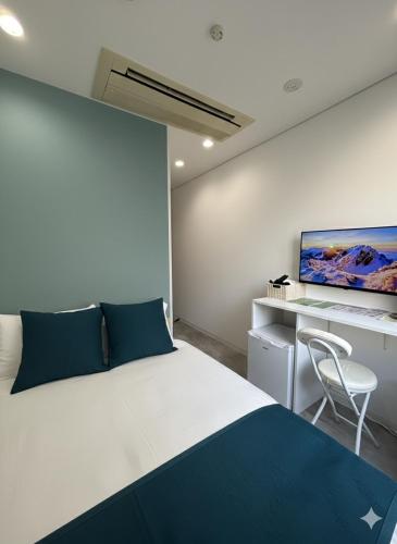 a bedroom with a bed and a desk and a tv at Hotel LEAP in Osaka
