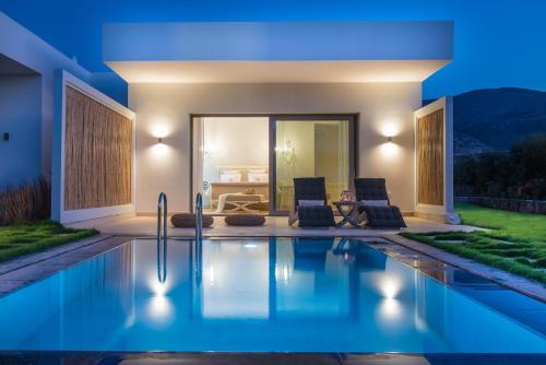 a villa with a swimming pool at night at Sunvillage Malia Boutique Hotel and Suites in Malia