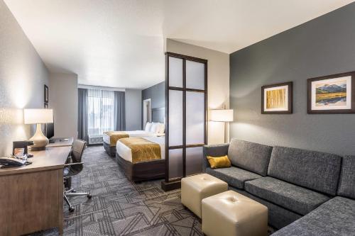 a hotel room with a couch and a bed at Comfort Inn & Suites Salt Lake City Airport in Salt Lake City