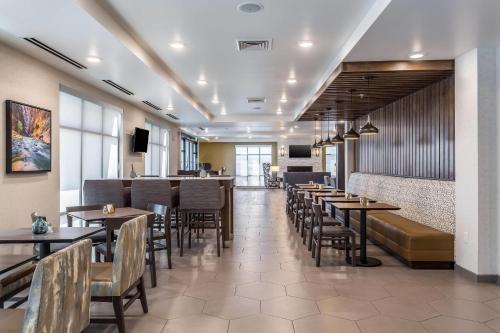 a restaurant with tables and chairs and a bar at Comfort Inn & Suites Salt Lake City Airport in Salt Lake City