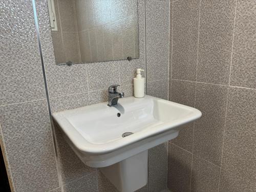 a bathroom with a white sink and a mirror at Le cocon éclatant in Sfax