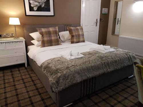 a bedroom with a large bed with towels on it at The Lion Hotel in Brewood