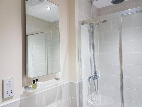a bathroom with a shower and a mirror at The Lion Hotel in Brewood