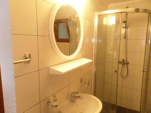 La salle de bains est pourvue d'un lavabo, d'un miroir et d'une douche. dans l'établissement Guesthouse Titi Mostar, à Mostar