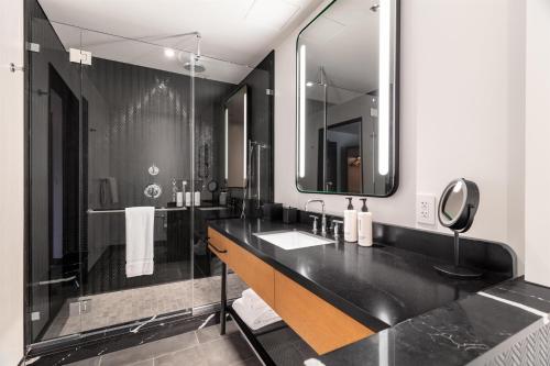 a black bathroom with a sink and a mirror at Canopy By Hilton Nashville Downtown The Gulch in Nashville