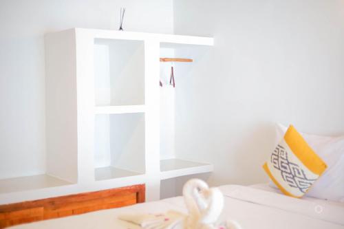 a bedroom with a bed with a window and a towel at Trytan Gerupuk Homestay in Bumbang