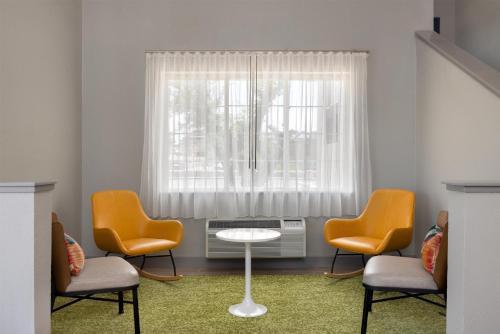 a waiting room with chairs and a table and a window at Spark by Hilton El Paso University in El Paso