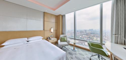 a hotel room with a bed and a large window at Lotte Hotel Hanoi in Hanoi