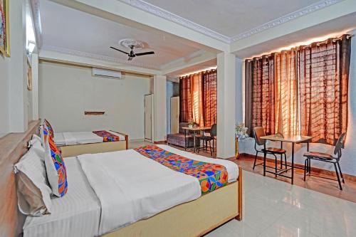 a bedroom with a bed and a table and chairs at FabHotel Sandalwood Vibes in Bhopal